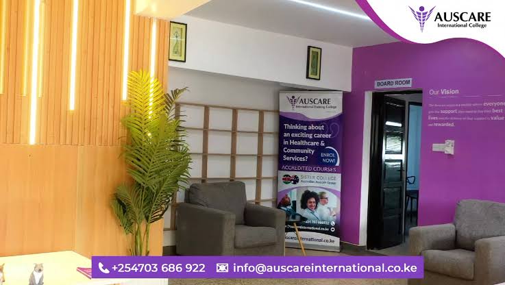 Lobby of AUSCARE International College with purple wall, banner about healthcare careers, and gray seating area including a plant and light panels.